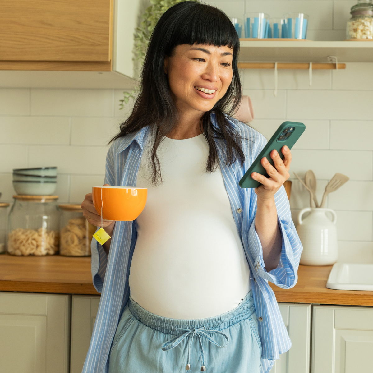 Pregnant person holding phone