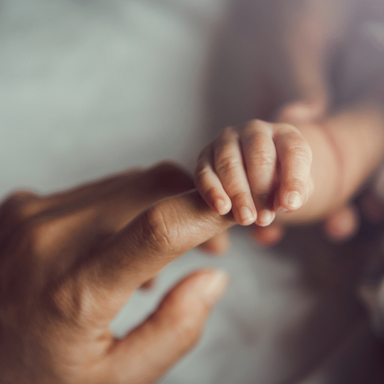 Baby holding mother's hand